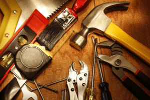 Many common handyman tools laid on workbench